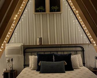 King bed in Tulip Glamping Aframe at Noble Pine Campground - Mammoth Cave - Bedroom