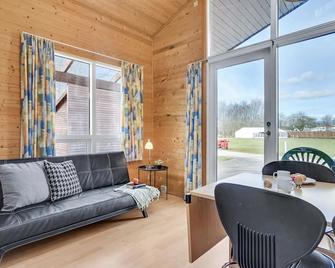 Comfortable camping vacation for young families in modern log cabin directly on the beach. - Fredericia - Living room