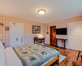 The wooden floors, vintage furniture, and tartan accents create a comfy room - Invergarry