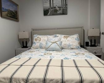 This two-bedroom cottage features one queen bed, two twin beds, and a sofa bed. - Nantucket - Bedroom