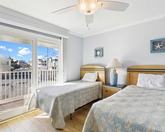 FREE ACTIVITIES!! Sitting directly on the ocean front nestled in the heart of down town this lovely 7 bedroom, 5 bath vacation home is the perfect central location to walk or bike ride anywhere in Bethany Beach! - Bethany Beach - Bedroom