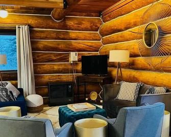 This beautiful log cottage has large windows that let in lots of light - Fairbanks - Living room