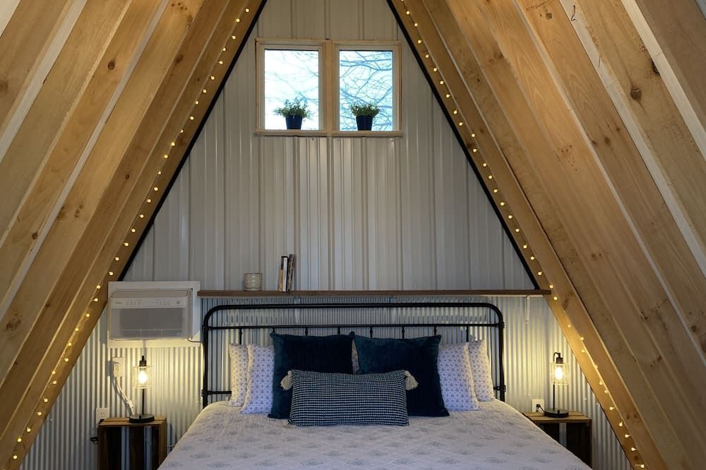 King bed in Tulip Glamping Aframe at Noble Pine Campground - Mammoth Cave - Bedroom