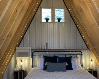 King bed in Tulip Glamping Aframe at Noble Pine Campground - Mammoth Cave - Bedroom