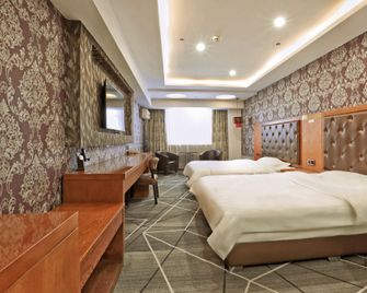 Dingyi Business Hotel (Harbin Dolphin Castle Hot Spring Water Park Branch) - Harbin - Bedroom