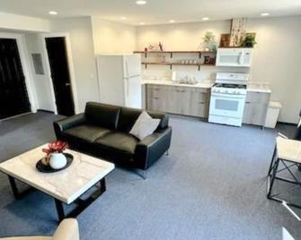 Cozy 2-bedroom suite with full kitchen, living room (couch, 2 chairs), dining table (2 stools), smart TV with cable. Perfect for short or long stays. - Arnolds Park - Living room