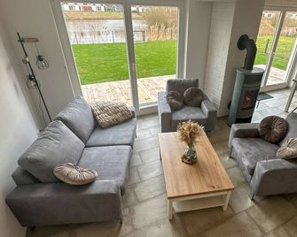 Vacation home Emily, modern furnished dog-friendly vacation home with 86m² and fenced garden. Relaxing bathroom with sauna, whirlpool and floor-level shower. Lockable bicycle shed - Nordhorn - Huiskamer