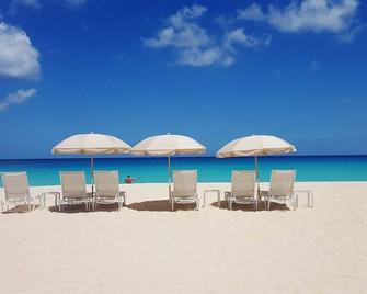 Breathtaking Sunset at Our Beach Front Stay | Living Area & Private Patio - Long Bay Village - Playa