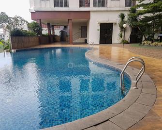 Modern Look and Comfortable 2BR Serpong Greenview Apartment By Travellio - Tangerang - Piscina