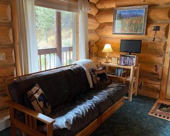 Our cozy, secluded cabin is nestled in Haywood Gulch with spectacular views of the Beartooth Mountains. Open layout cabin with full kitchen with dining table and chairs. Comfortable plush queen log bed. Futon couch T.V. Great deck with seating areas, - Red Lodge - Living room
