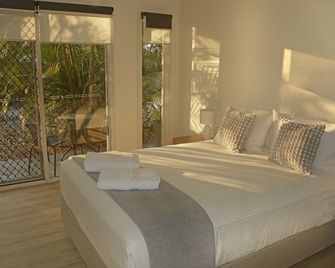 Sea Breeze & partial Water Views among the palm tree canopy -Apt 4. - 우란간 - 침실