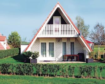 This cozy cottage is located on the edge of a vacation park, thereby you have a view of the dike fro - Den Oever - Edificio